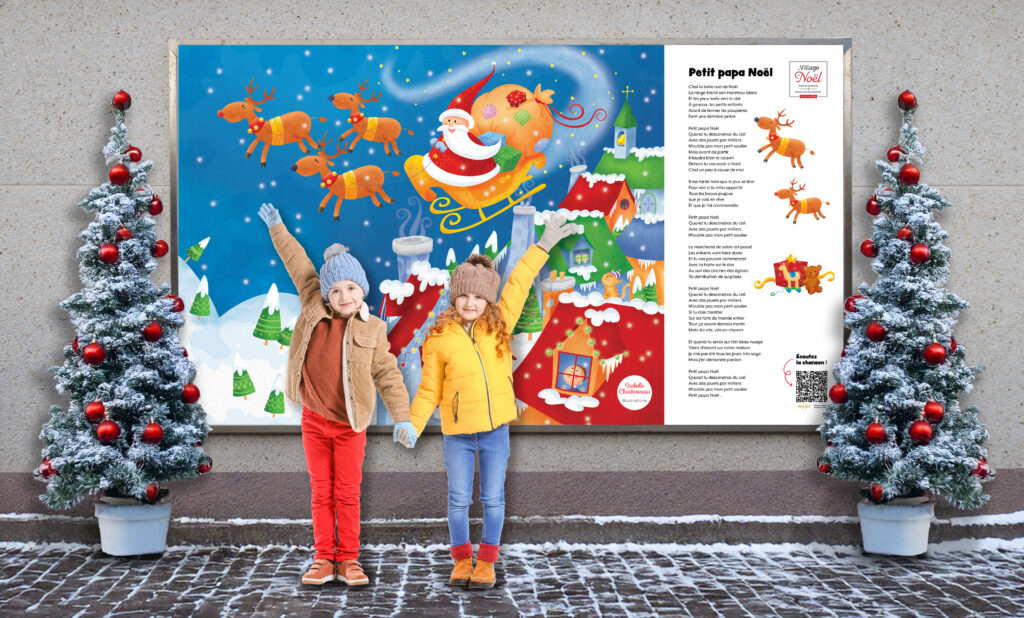 Deux enfants à l'extérieur devant un mur où il y a une grande illustration du père Noël par Isabelle Charbonneau avec deux sapins de Noël.